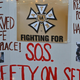 Wynema Chavez Quintana holds a sign calling for better safety on movie sets during a vigil held to honor cinematographer Halyna Hutchins at Albuquerque Civic Plaza on October 23, 2021